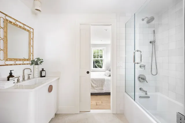 a bathroom with a bathtub shower sink and mirror