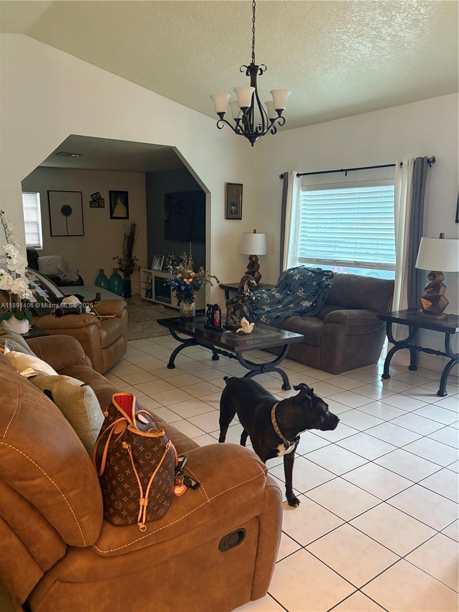 12601 Southwest 268th Street Homestead, FL 33032 - Photo 16 of 17 a living room with furniture and a chandelier