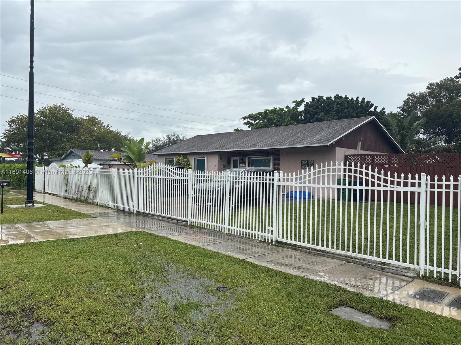 12601 Southwest 268th Street Homestead, FL 33032 - Photo 2 of 17 a view of a house with a small yard and wooden fence