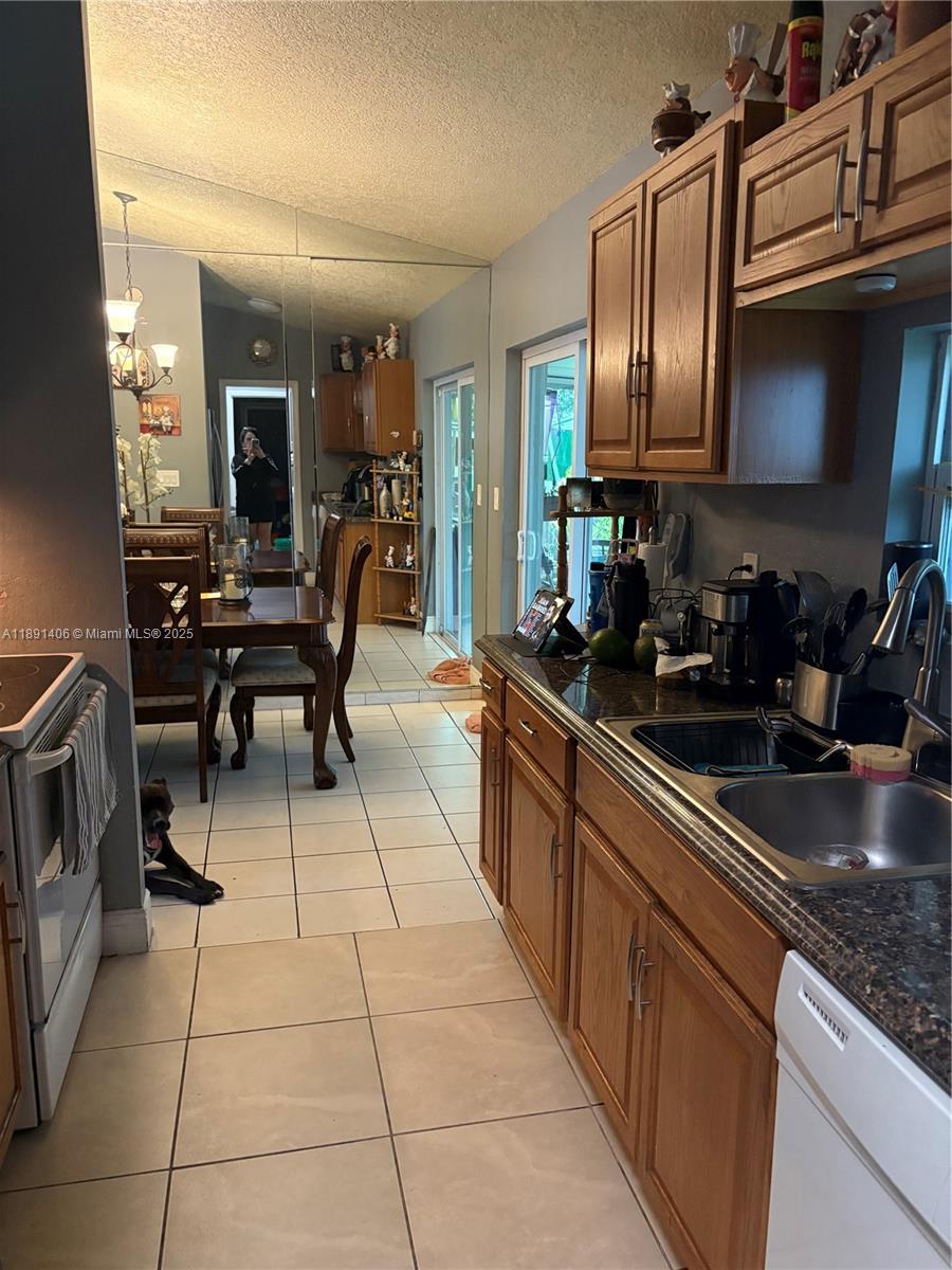 12601 Southwest 268th Street Homestead, FL 33032 - Photo 3 of 17 a kitchen with stainless steel appliances granite countertop a sink and cabinets