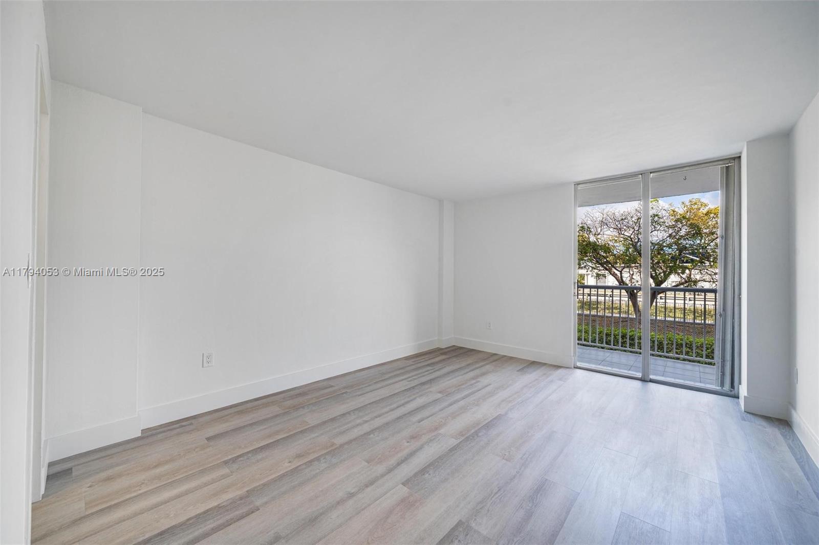 150 Southeast 25th Road, Unit 2H Miami, FL 33129 - Photo 6 of 15 an empty room with wooden floor and windows