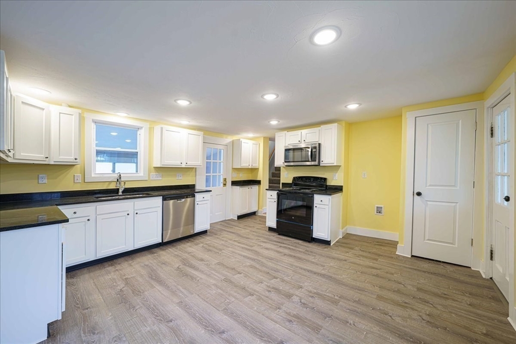 42 Silver Hill Road Milford, MA 01757 - Photo 5 of 30 a large kitchen with stainless steel appliances kitchen island granite countertop a stove top oven a sink and dishwasher with wooden floor