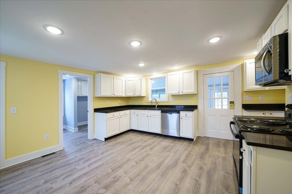 42 Silver Hill Road Milford, MA 01757 - Photo 6 of 30 a kitchen with stainless steel appliances granite countertop a stove a sink a refrigerator white cabinets and wooden floor