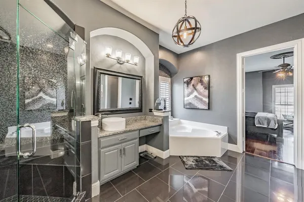 a spacious bathroom with a double vanity sink a mirror a bathtub and a shower