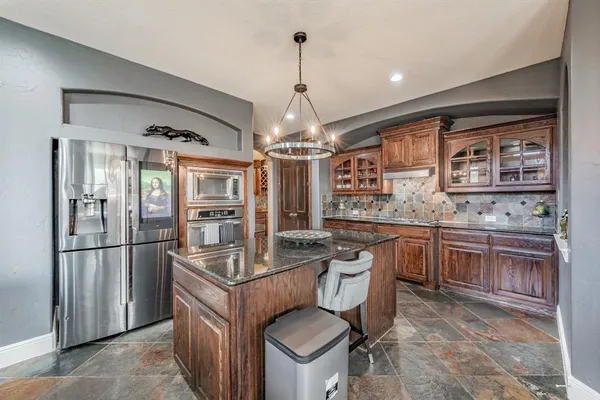 a kitchen with stainless steel appliances granite countertop a stove refrigerator and cabinets