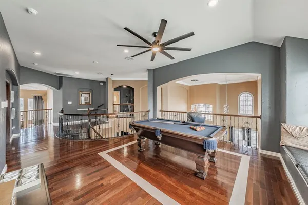 a living room with furniture a wooden floor and a ceiling fan