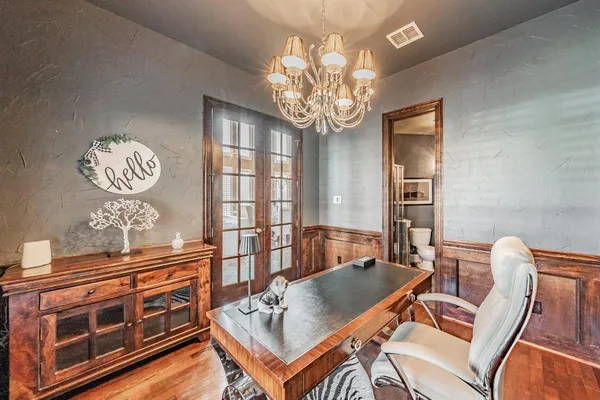 a view of a dining room with furniture a chandelier and wooden floor