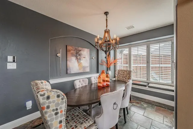 a dining room with furniture a chandelier and window