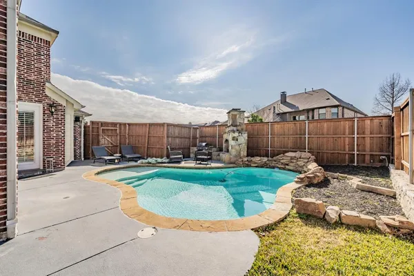 a view of a house with swimming pool and sitting area