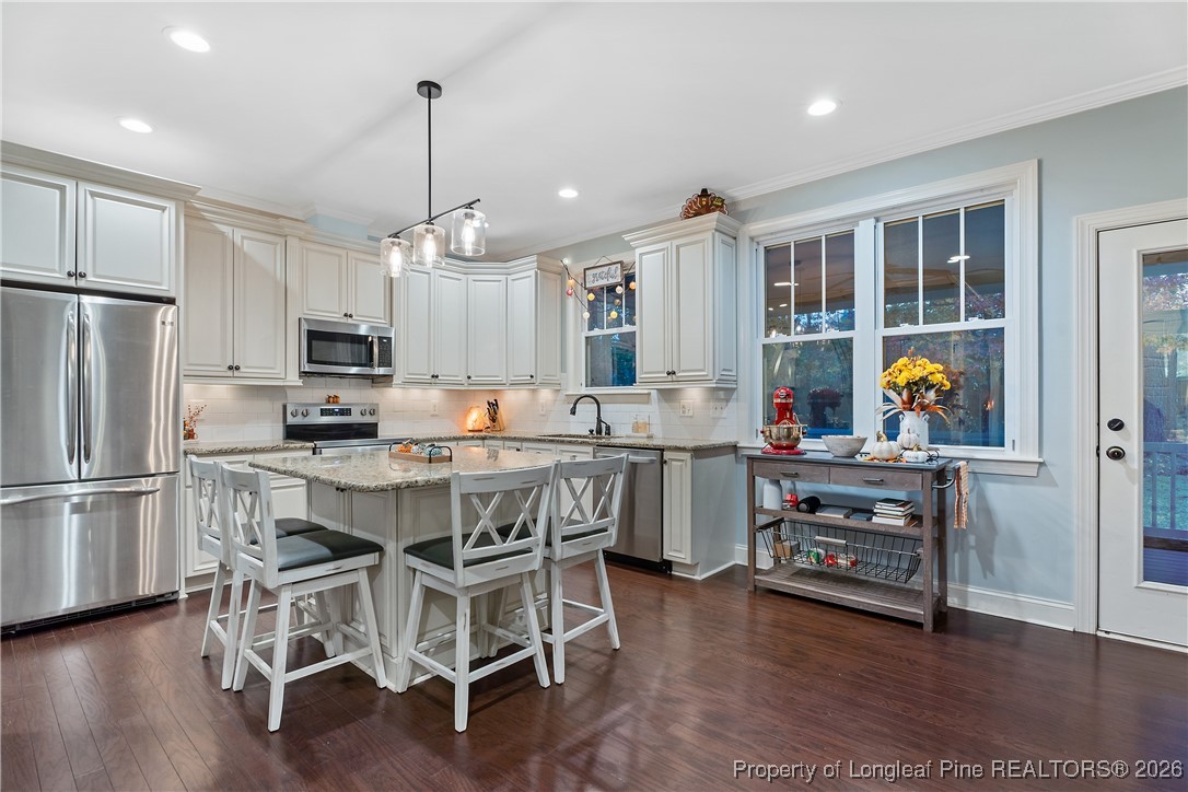 38 Overview Court Spring Lake, NC 28390 - Photo 9 of 50 a kitchen with stainless steel appliances a stove a refrigerator and a dining table with wooden floor