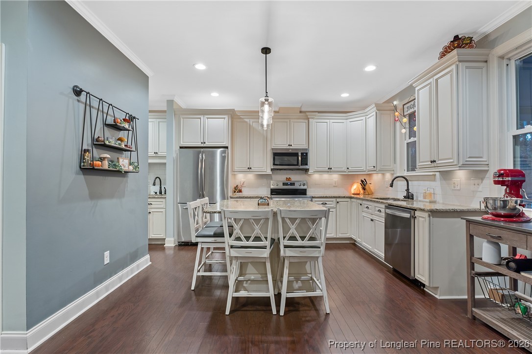38 Overview Court Spring Lake, NC 28390 - Photo 10 of 50 a kitchen with kitchen island granite countertop a table chairs refrigerator and microwave