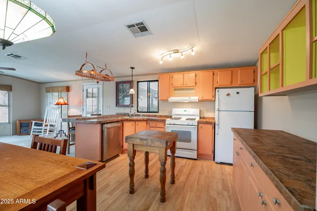 a kitchen with stainless steel appliances granite countertop table chairs sink and cabinets