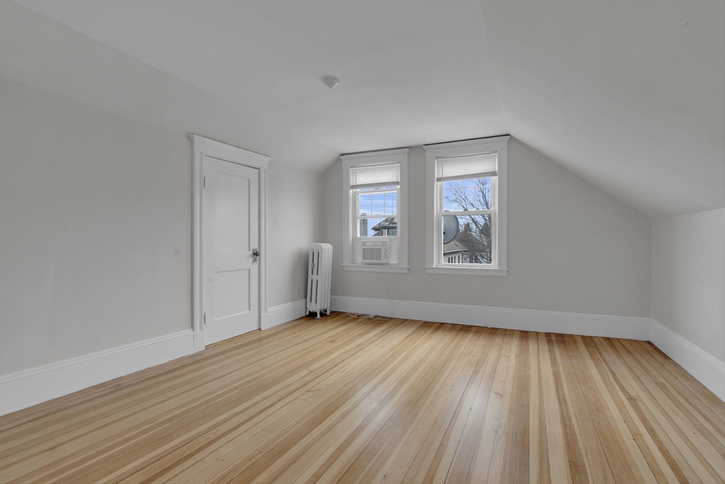 64 Commonwealth Road Watertown, MA 02472 - Photo 20 of 23 a view of an empty room with wooden floor and a window