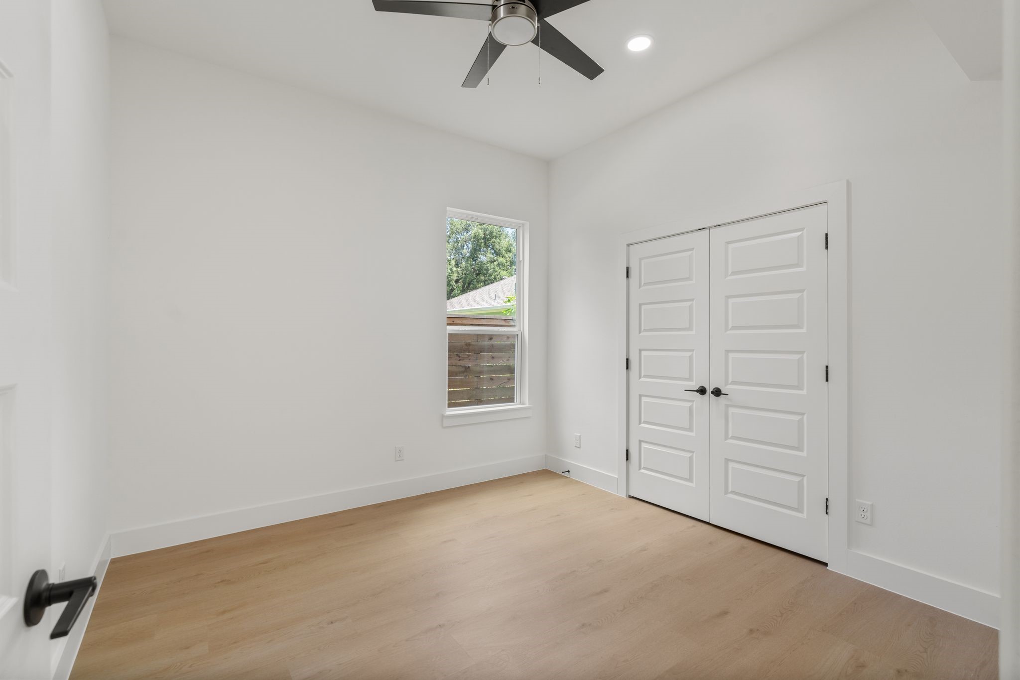 7321 Laura Koppe Road Houston, TX 77028 - Photo 30 of 41 Bright and airy room featuring sleek
hardwood floors, a modern ceiling fan, and ample
natural light from a single window, complemented
by double doors for added storage.