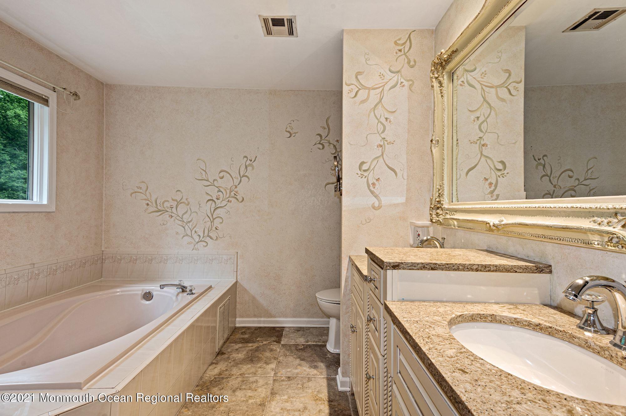 256 Nottingham Road Morganville, NJ 07751 - Photo 23 of 41 a bathroom with a granite countertop tub sink and mirror