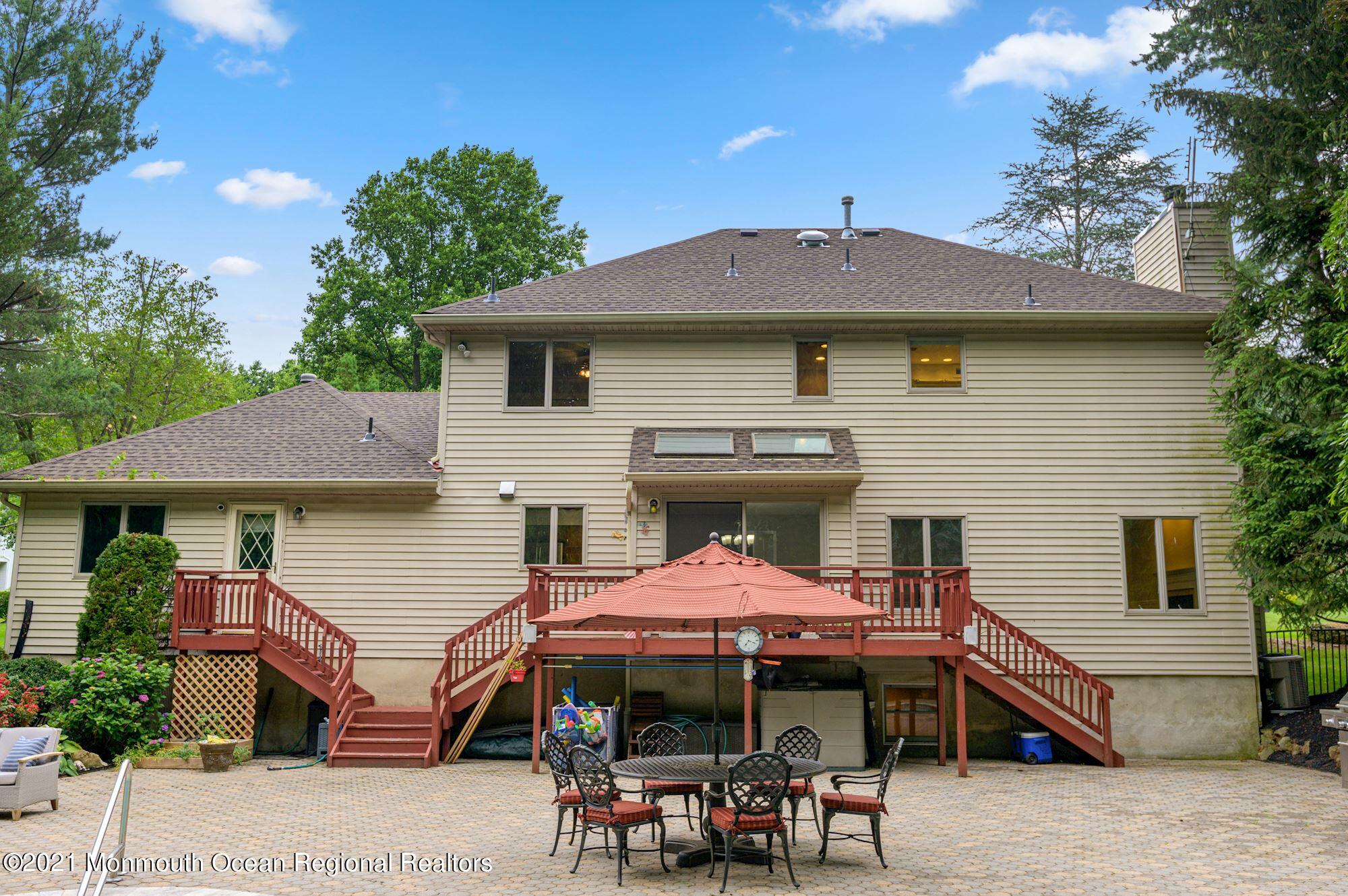 256 Nottingham Road Morganville, NJ 07751 - Photo 41 of 41 a front view of a house with table and chairs under an umbrella