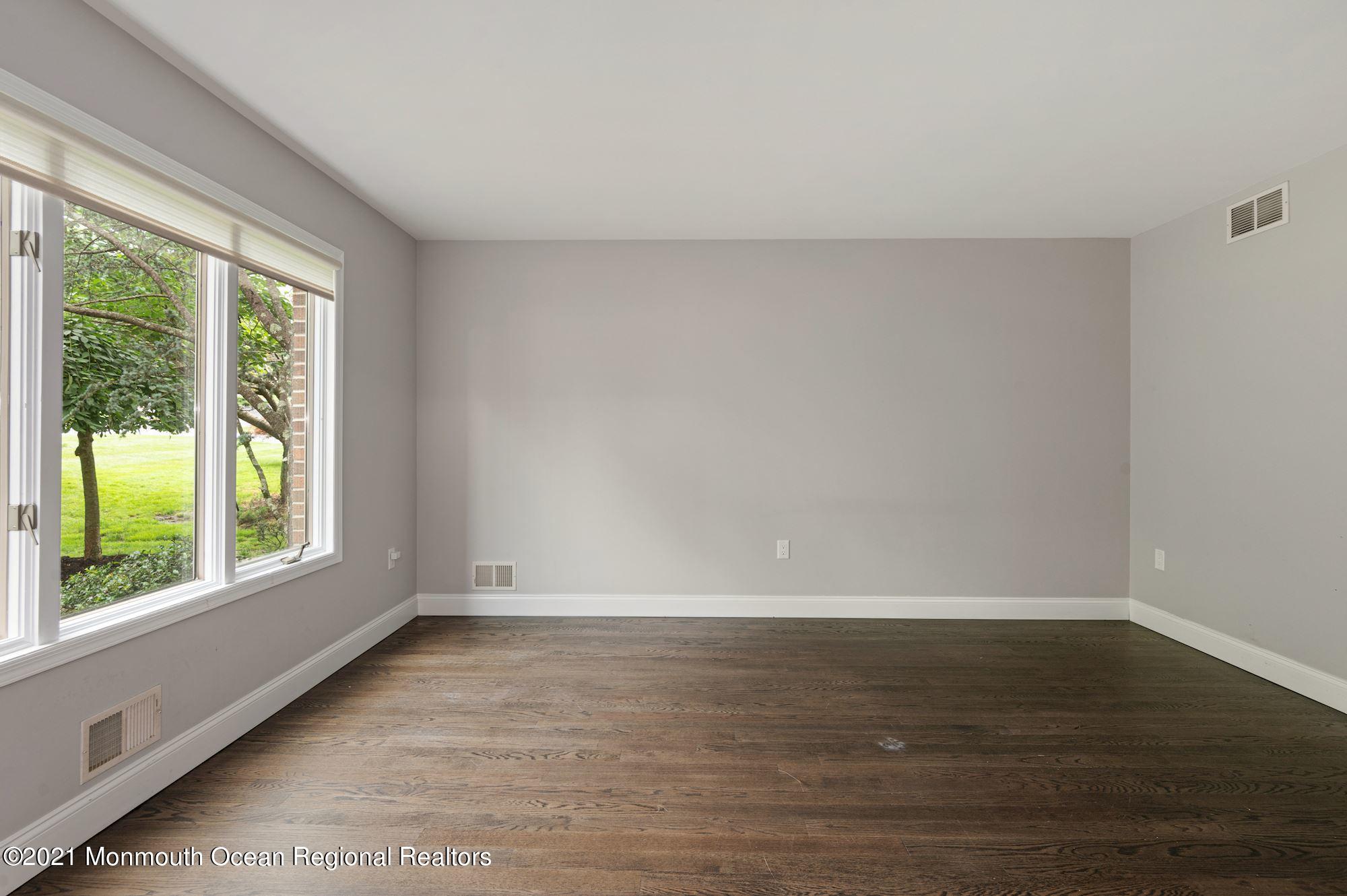 256 Nottingham Road Morganville, NJ 07751 - Photo 9 of 41 a view of an empty room with wooden floor and a window