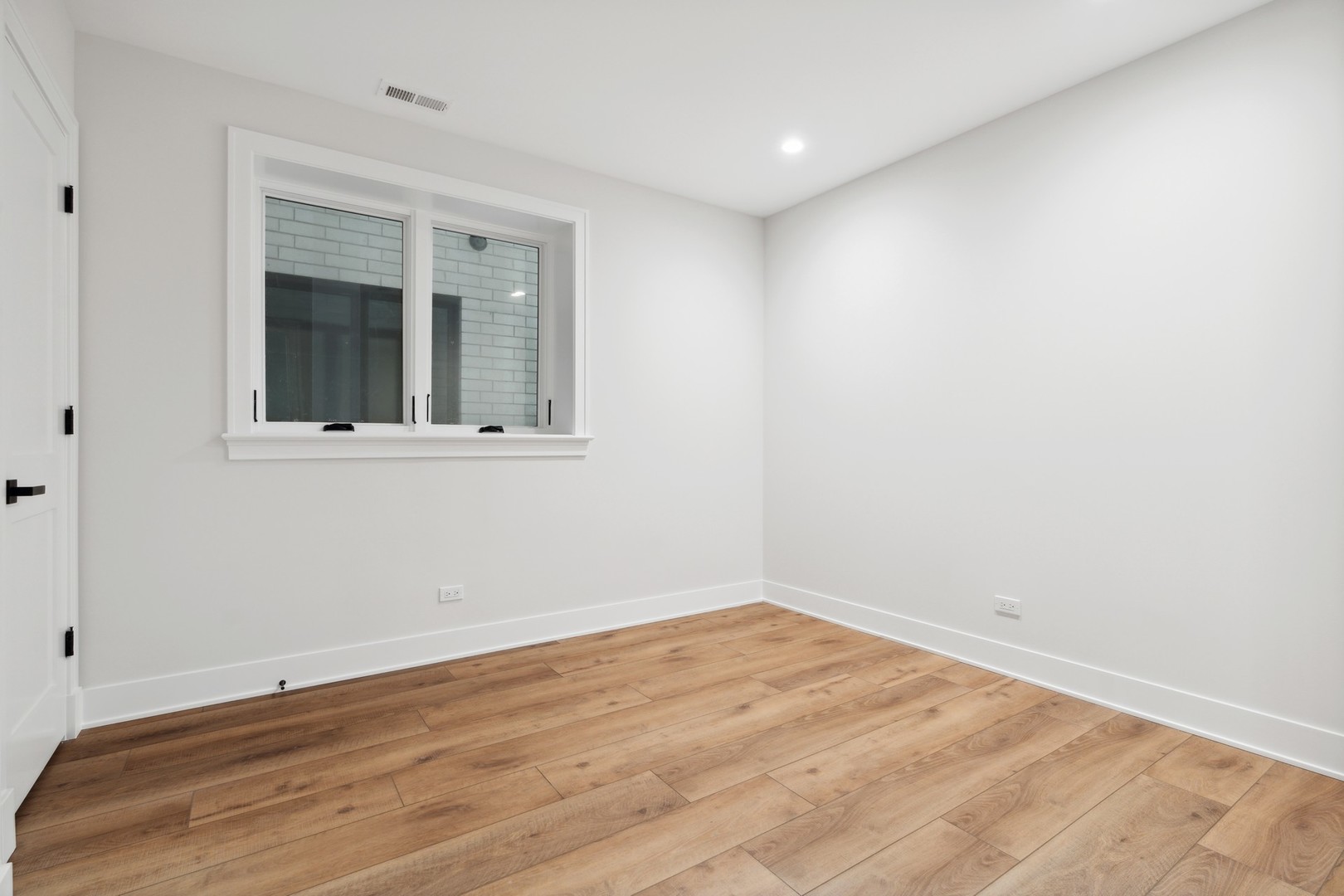 232 South Green Street, Unit 1S Chicago, IL 60607 - Photo 24 of 40 an empty room with wooden floor and windows