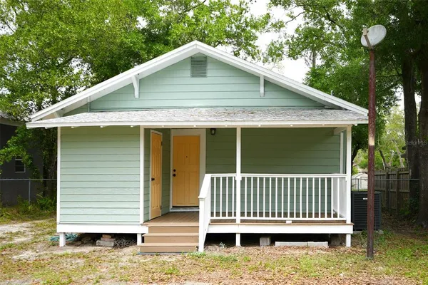 a porch with a bench next to a yard