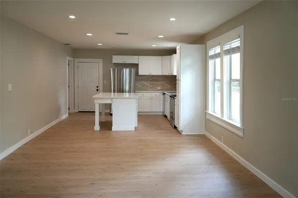 a view of a kitchen with a sink and dishwasher a refrigerator with wooden floor