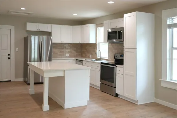 a kitchen with a sink stainless steel appliances and cabinets