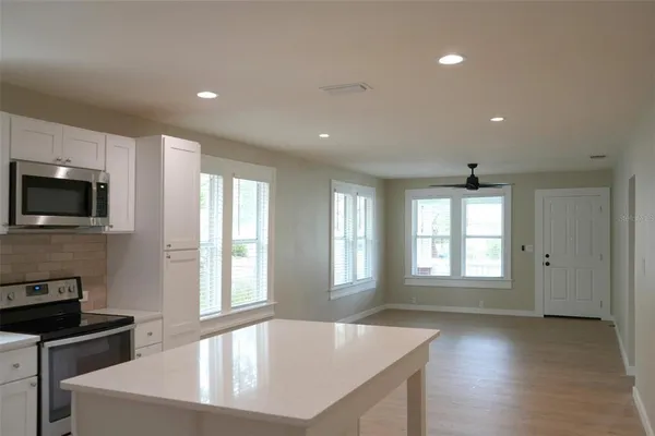 a large kitchen with sink a window and stainless steel appliances