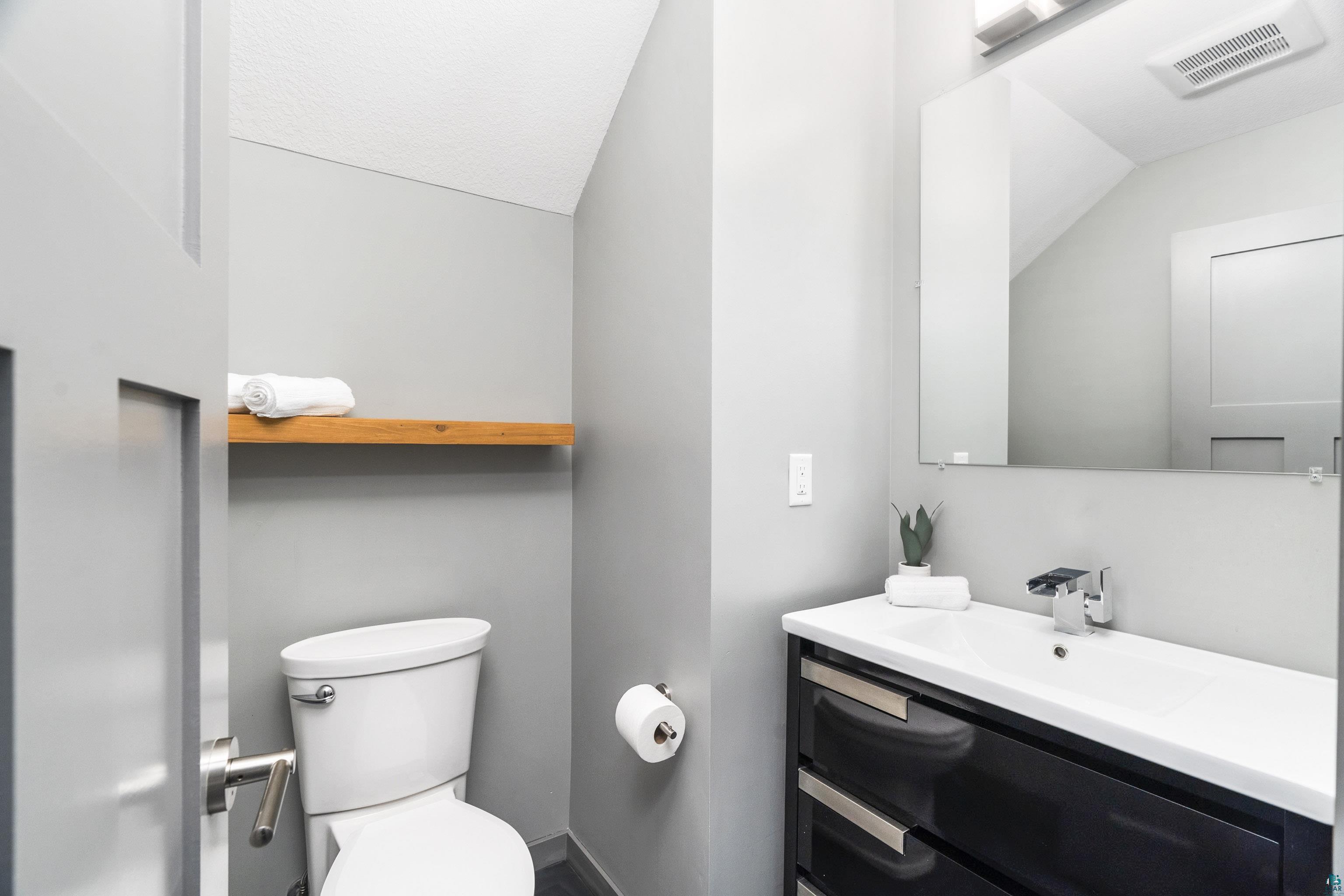 3625 London Road Duluth, MN 55804 - Photo 11 of 28 Bathroom with vaulted ceiling, oversized vanity, and toilet