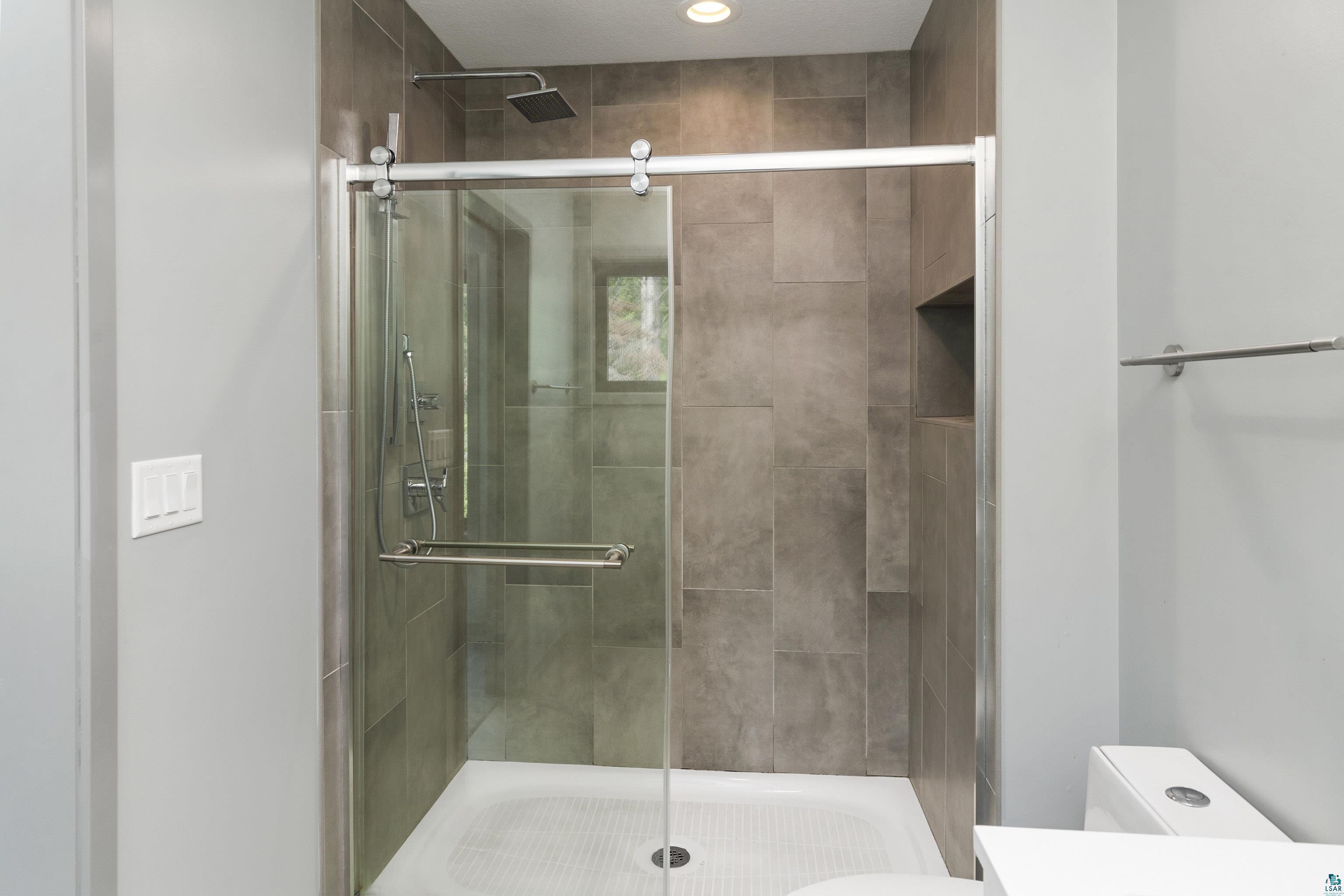3625 London Road Duluth, MN 55804 - Photo 17 of 28 Bathroom with a shower with shower door and toilet