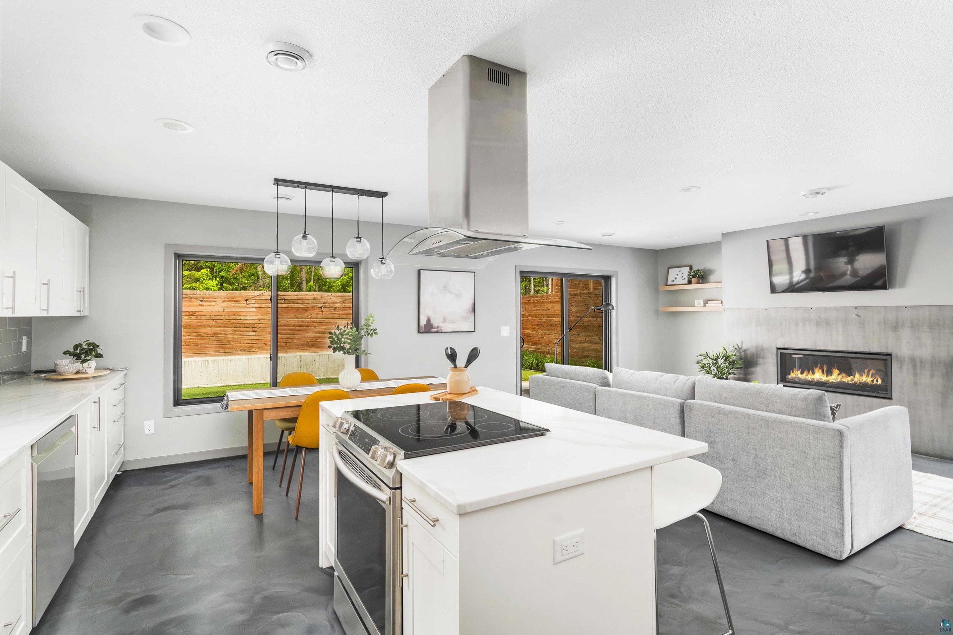 3625 London Road Duluth, MN 55804 - Photo 10 of 28 Kitchen featuring stainless steel appliances, white cabinetry, a center island, ventilation hood, and pendant lighting