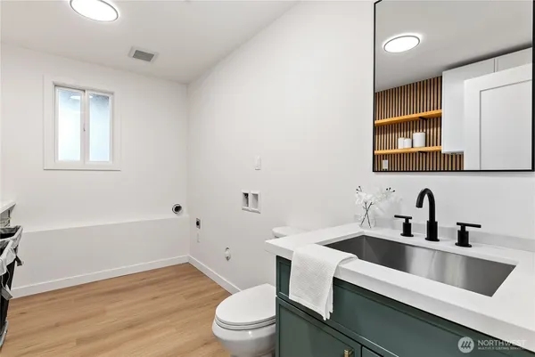 a bathroom with a sink a toilet and shower