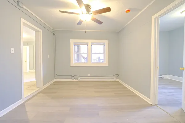 an empty room with windows and fan