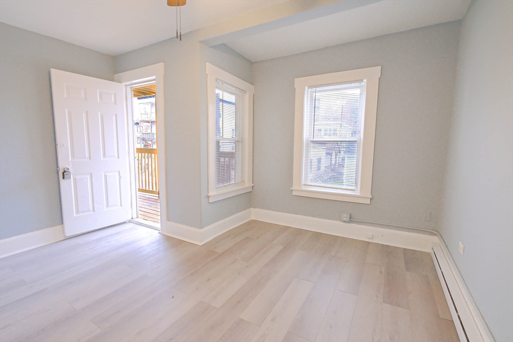105 Clarendon Street, Unit 2 Fitchburg, MA 01420 - Photo 24 of 30 an empty room with wooden floor and windows