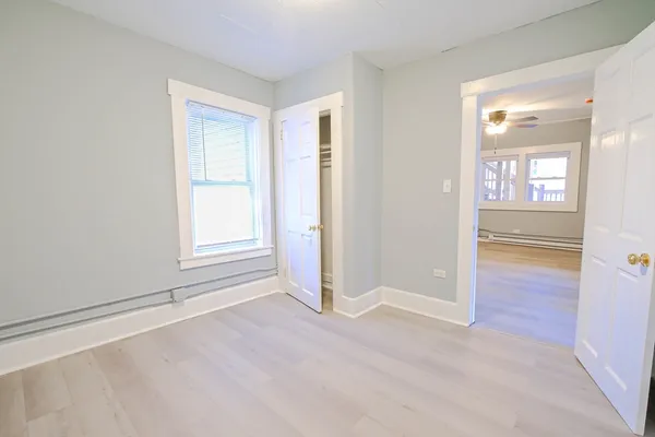 an empty room with a window and wooden floor