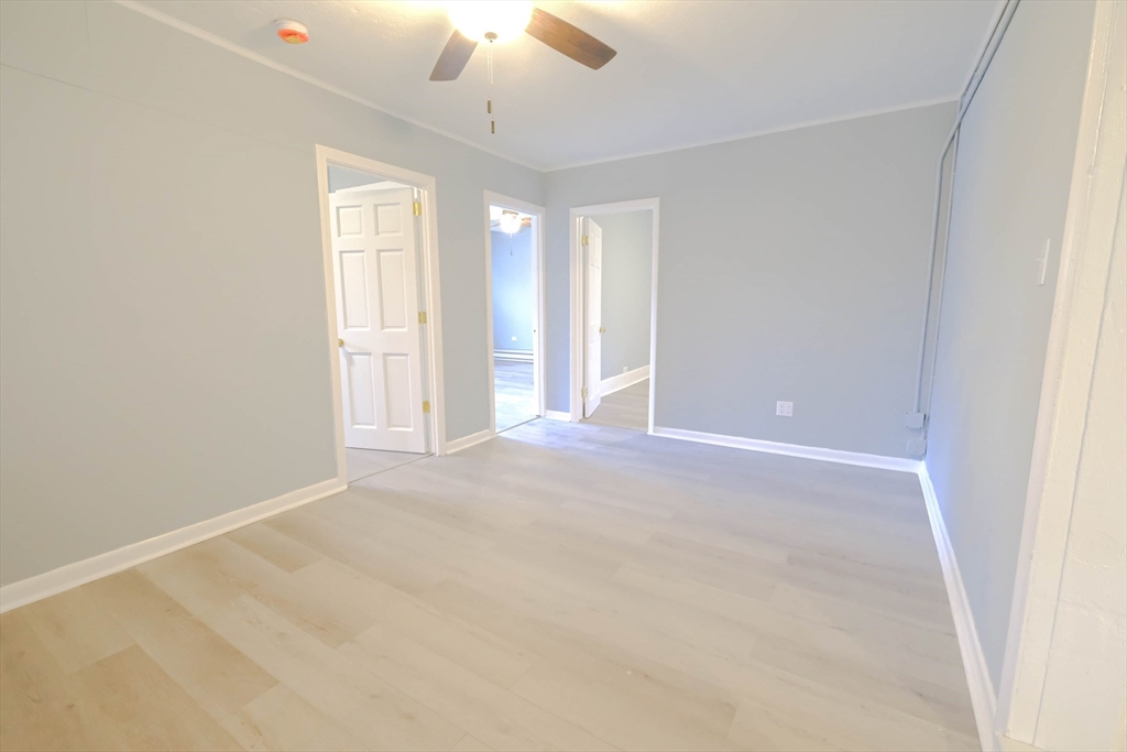 105 Clarendon Street, Unit 2 Fitchburg, MA 01420 - Photo 27 of 30 an empty room with a chandelier fan and windows