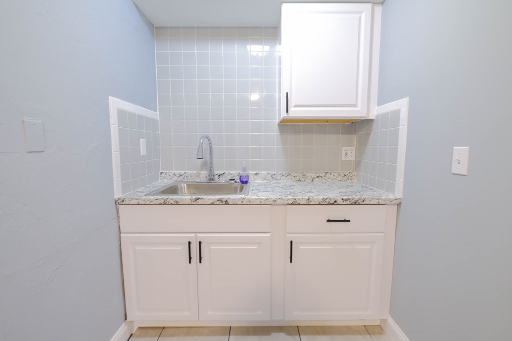 105 Clarendon Street, Unit 2 Fitchburg, MA 01420 - Photo 3 of 30 a bathroom with a granite countertop sink and a mirror