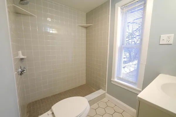 a bathroom with a toilet and a shower