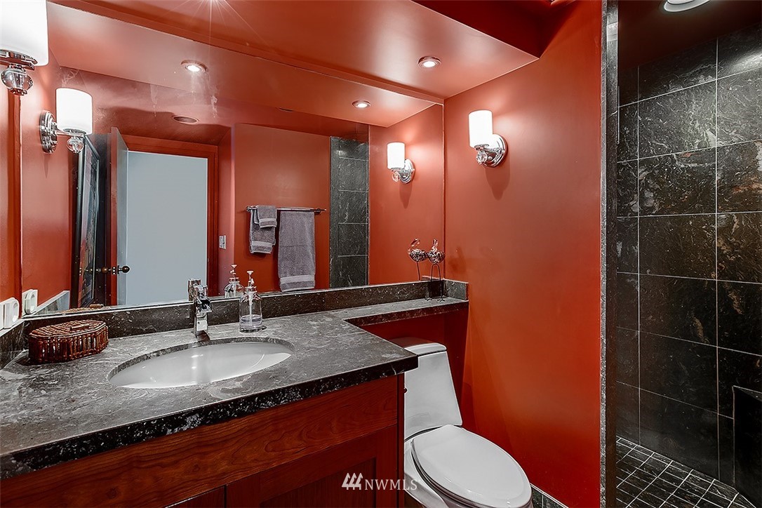 2021 1st Avenue, Unit E6 Seattle, WA 98121 - Photo 25 of 32 a bathroom with a granite countertop sink vanity mirror and toilet