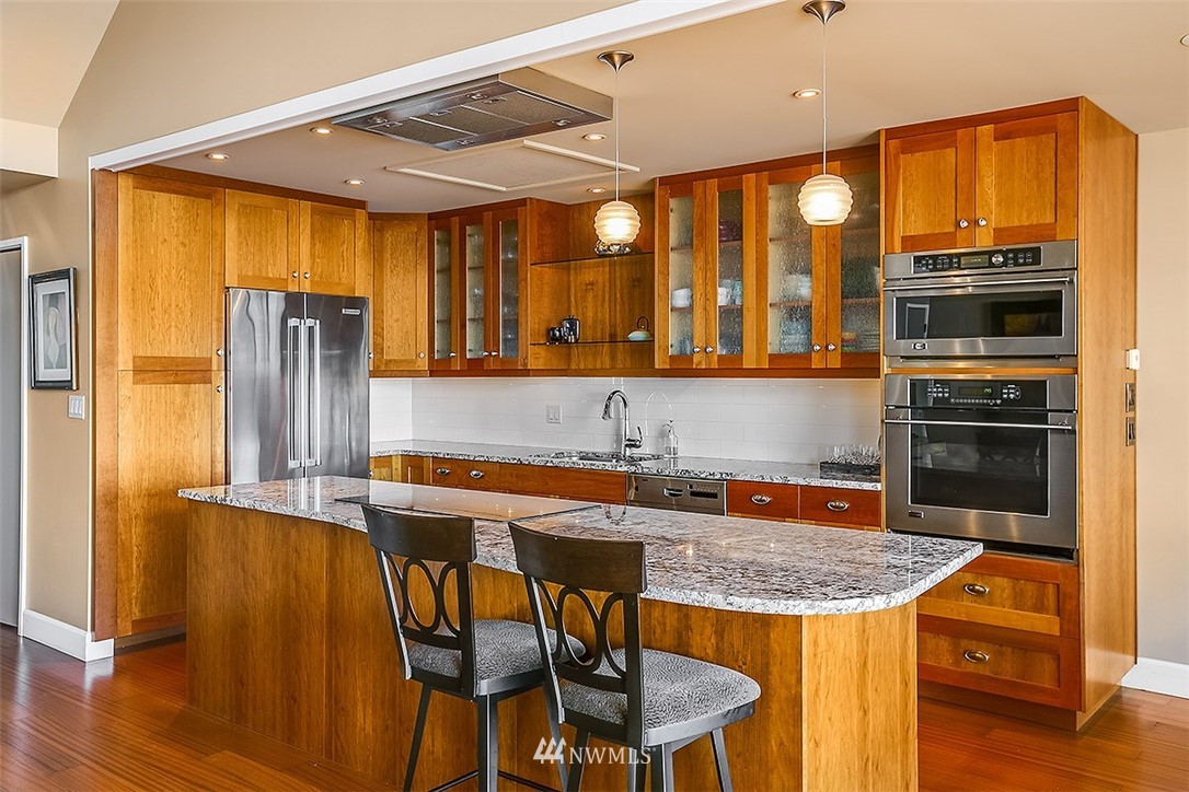 2021 1st Avenue, Unit E6 Seattle, WA 98121 - Photo 8 of 32 a kitchen with stainless steel appliances granite countertop a stove refrigerator and a refrigerator