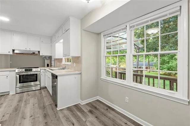 a kitchen with a stove a sink and a window