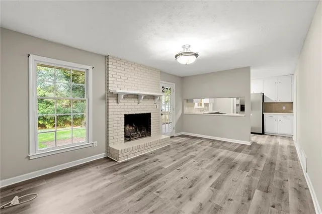 a view of empty room with a fireplace and wooden floor
