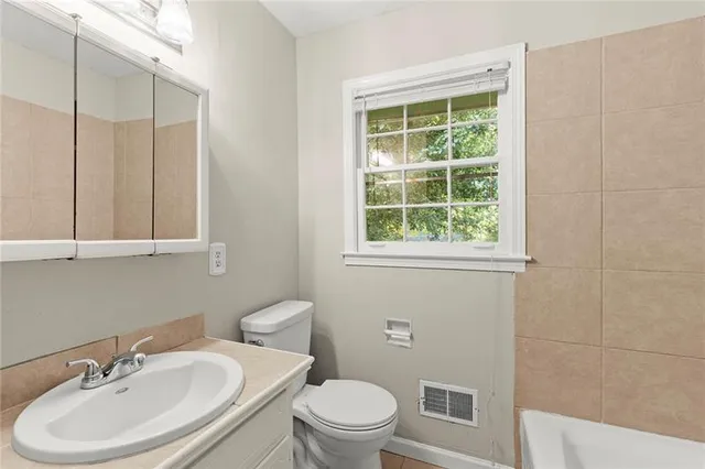 a bathroom with a sink a toilet and a mirror