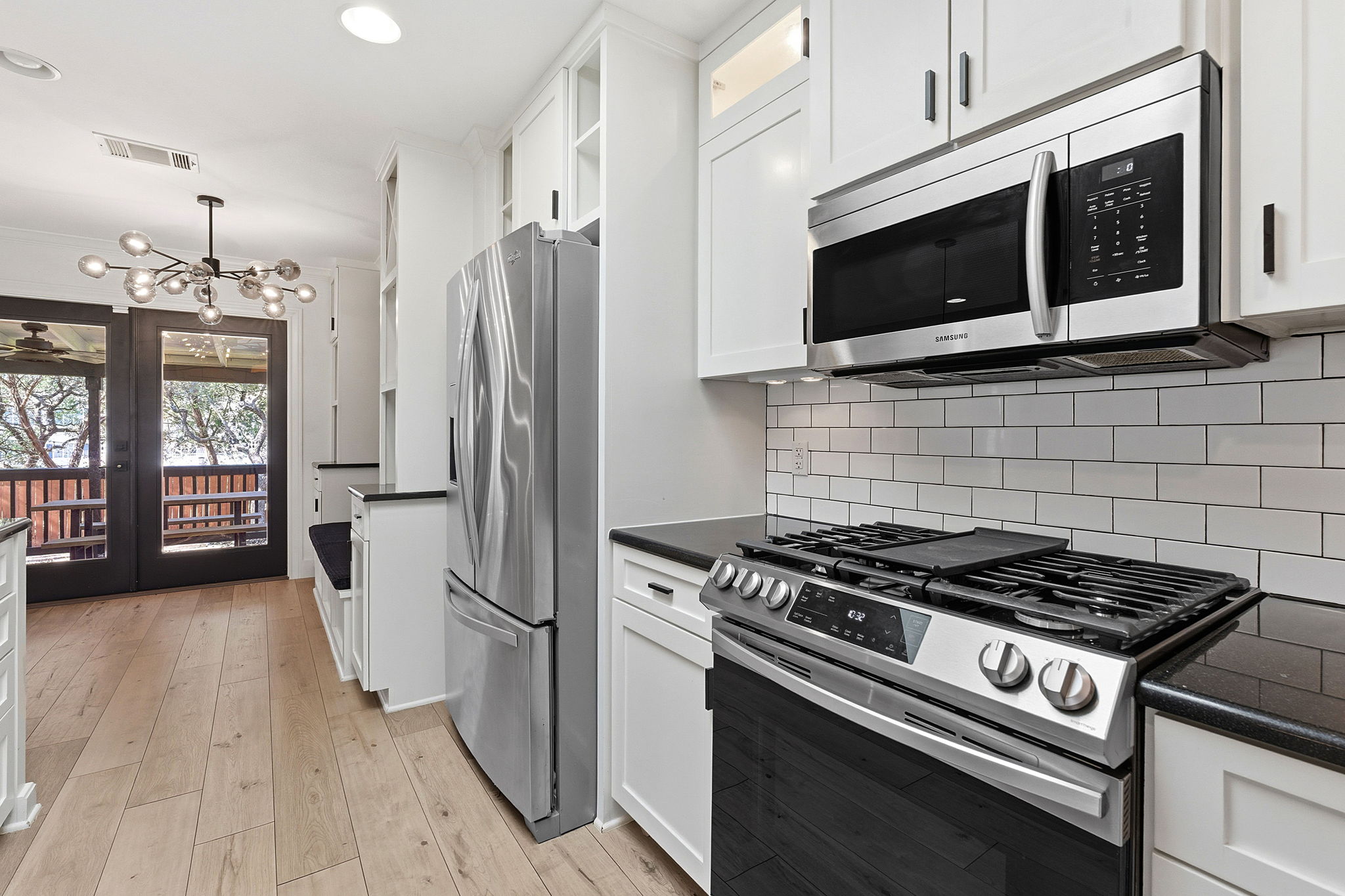 1511 Knoll Ridge Drive Cedar Park, TX 78613 - Photo 7 of 26 Kitchen featuring stainless steel appliances, hanging lights, white cabinets, light wood-type flooring, and french doors