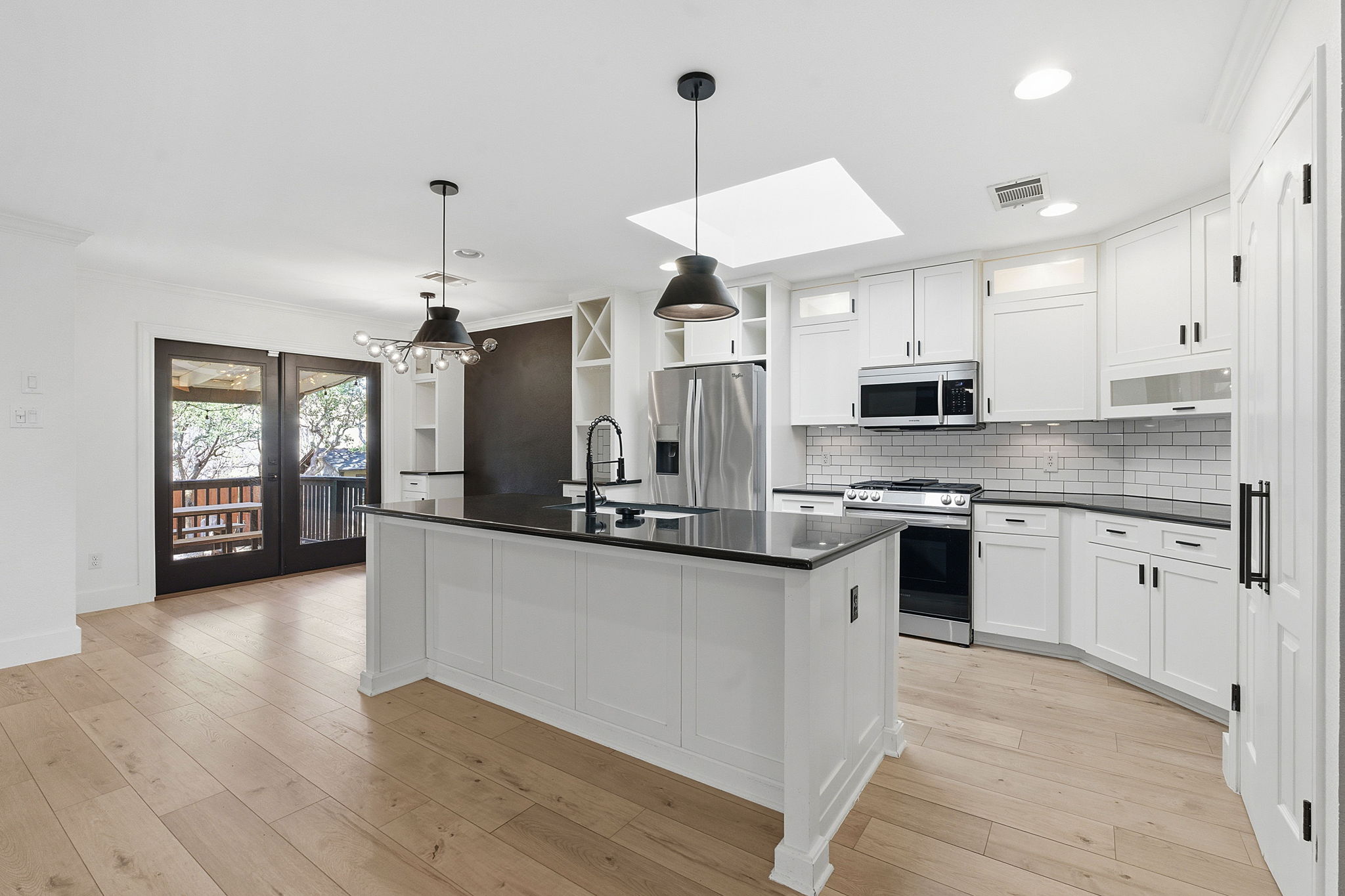 1511 Knoll Ridge Drive Cedar Park, TX 78613 - Photo 9 of 26 Kitchen featuring open shelves, a skylight, stainless steel appliances, decorative light fixtures, and white cabinetry