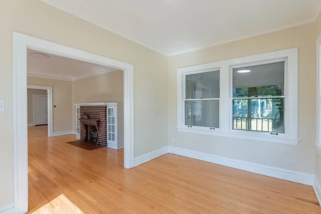 a view of empty room with wooden floor and fireplace