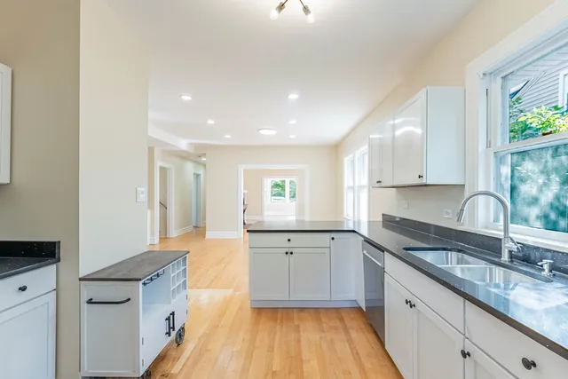 a kitchen with granite countertop a sink stove and cabinets
