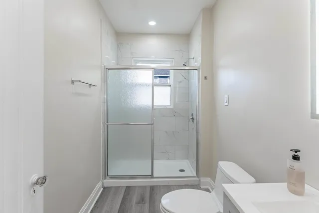 a bathroom with a granite countertop sink mirror vanity and toilet