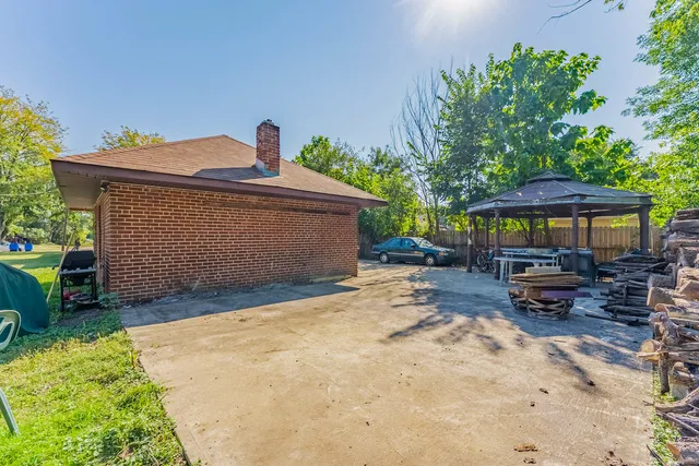 a view of a house with backyard and sitting area