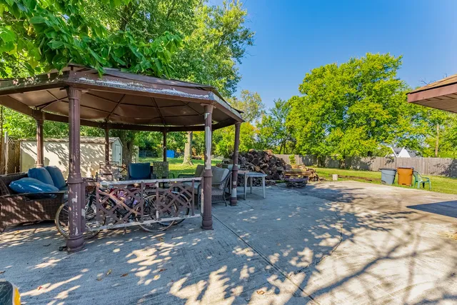 a view of patio with table and chairs under an umbrella