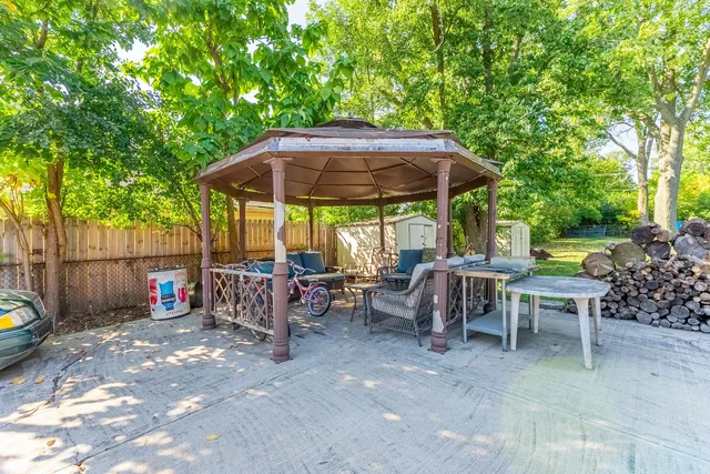 a view of patio with chairs and table under an umbrella