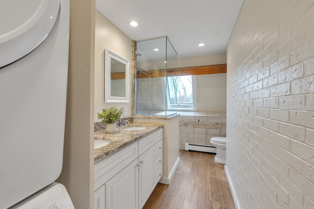 89 Kittery Avenue Rowley, MA 01969 - Photo 13 of 37 a bathroom with a granite countertop sink a large mirror a toilet and bathtub